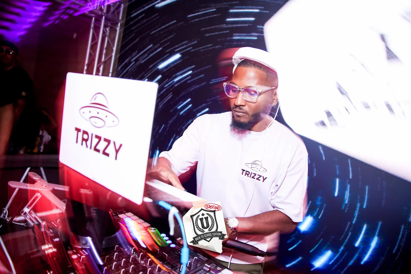 DJ Trizzy mixing with light trails streaking across the LED wall behind him